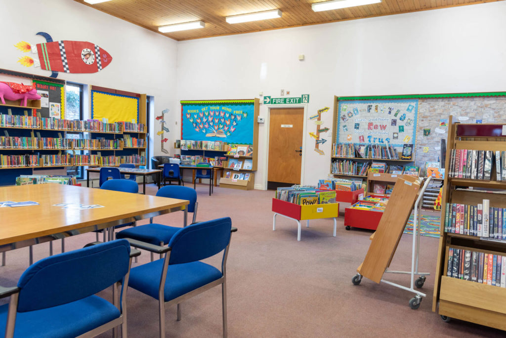 Children's area at Langport Library with colourful book displays, activity tables, seating and shelves of children's books for reading and learning