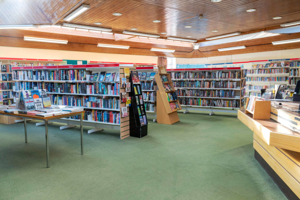 Main library area at Wincanton Library with fiction, crime and biography collections, featured book displays, customer service desk and open space for browsing and borrowing.