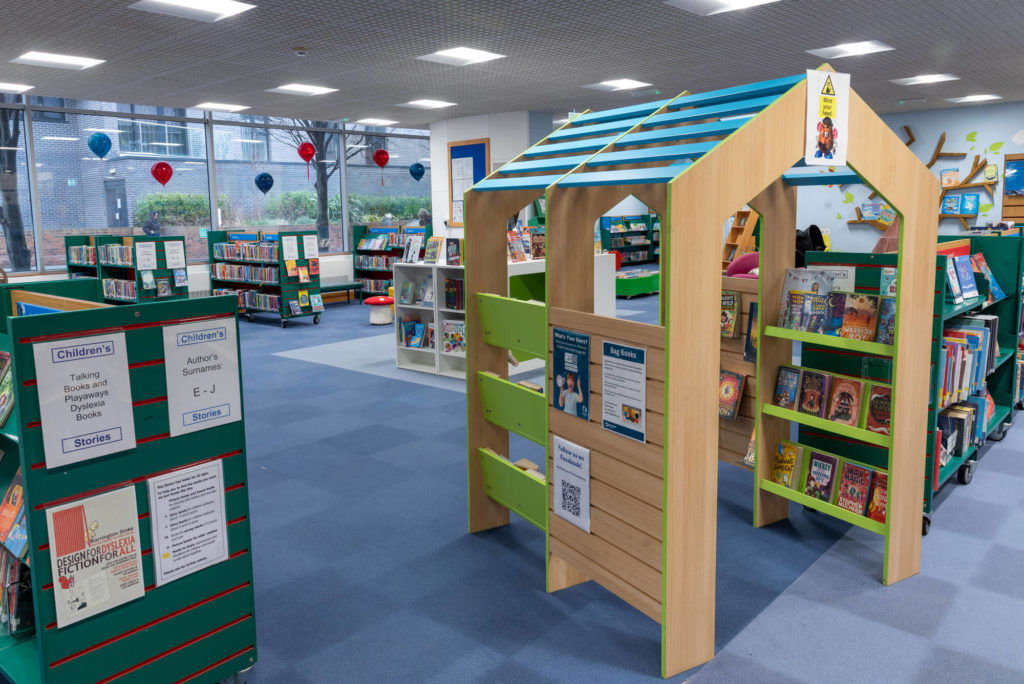 Children's library area at Taunton Library with themed book displays, low-level shelving, a wooden reading structure and colourful spaces for young readers to explore books and stories.
