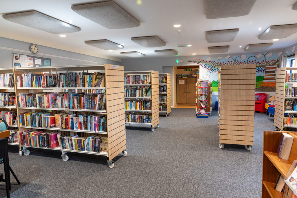 Main library area at North Petherton Library with fiction book collections, wide browsing aisles, children's area and open space for reading and borrowing.
