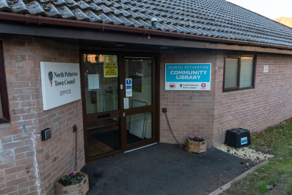 Exterior of North Petherton Community Library showing the main entrance, library signage and accessible access on a single-storey brick building