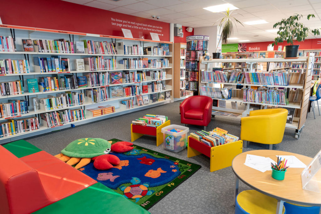 Children's and family area at Priorswood Library with colourful seating, picture book displays, activity table, reading rug and shelves of books for all ages.