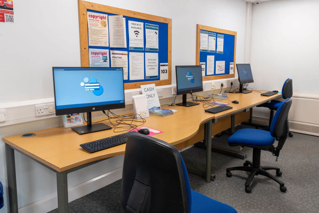 Public access computer area at Priorswood Library with desktop workstations, accessible seating, information boards and facilities for internet access, printing and online services.
