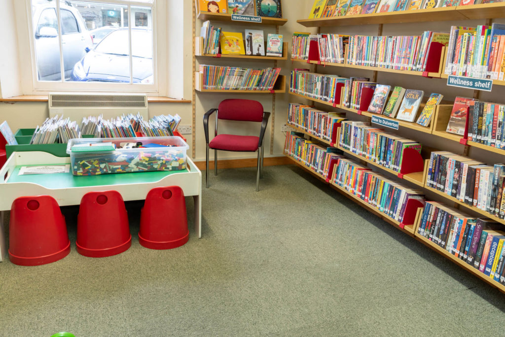 Children's reading area at Dulverton Library with picture books, wellness shelf, activity table and seating for young readers.