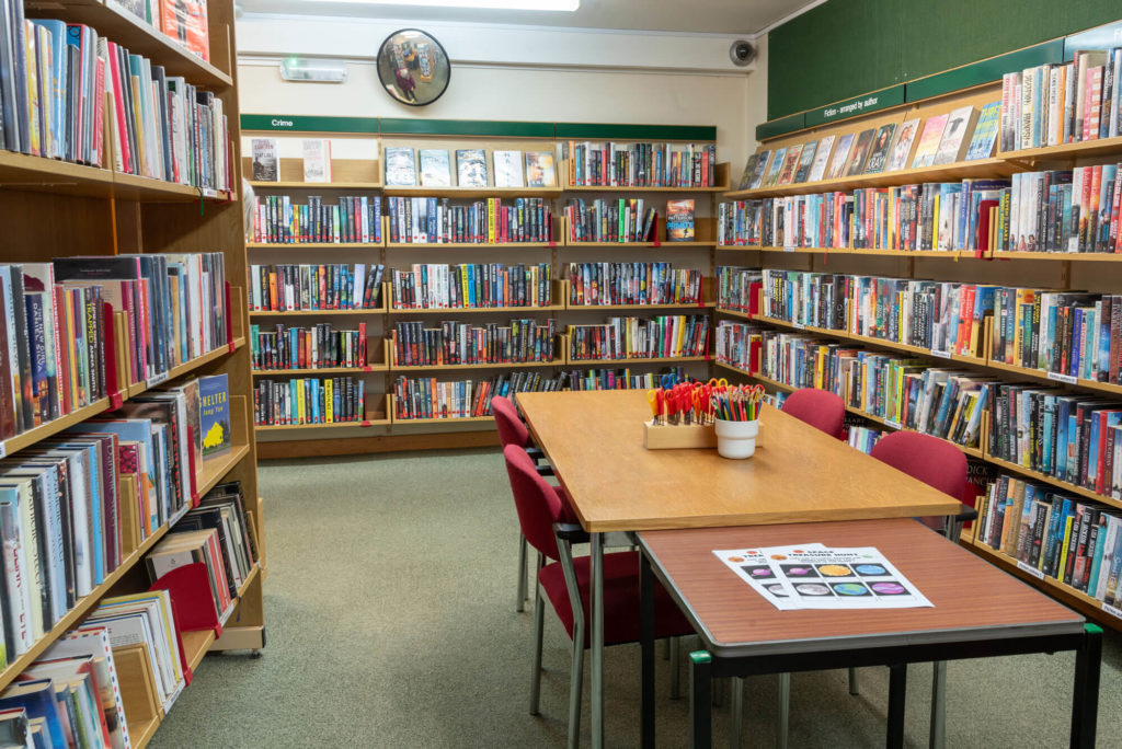 Fiction and crime book collections at Dulverton Library with study tables, seating and shelves arranged for browsing and reading.