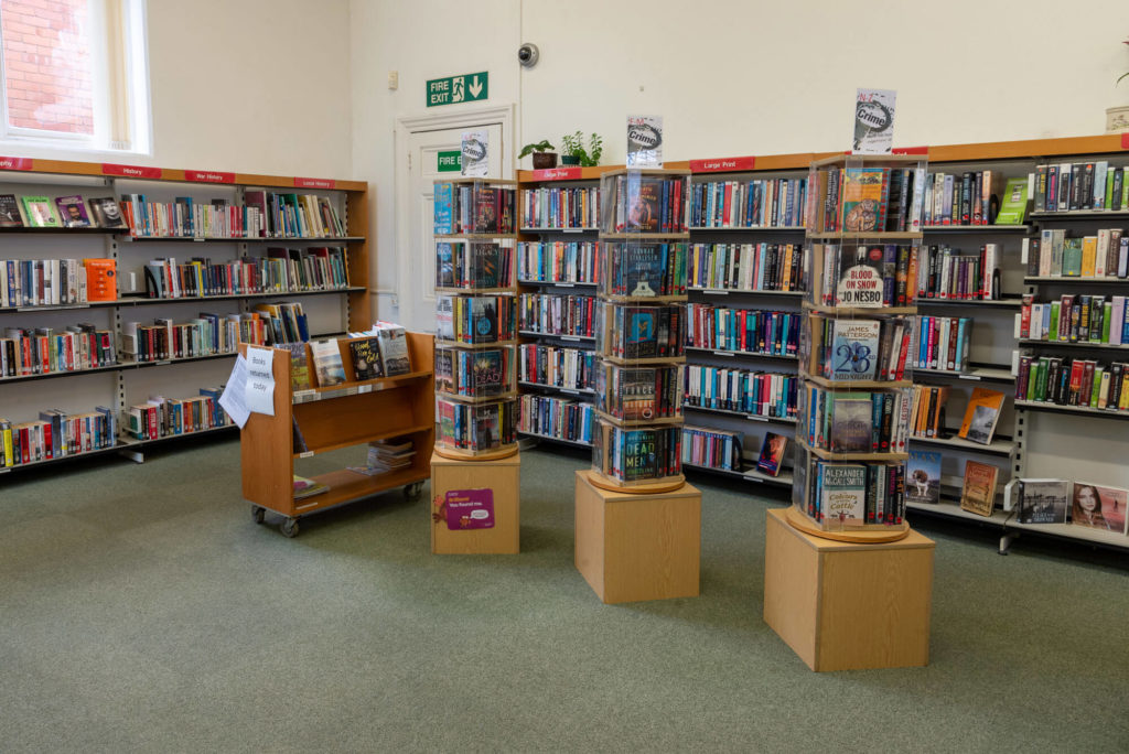 Adult fiction and local history collections at Ilminster Library with book shelves, featured displays and browsing space for readers.