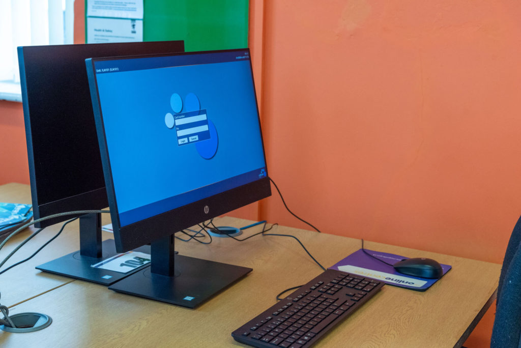 Public access computer workstation at Ilminster Library with desktop PCs, keyboard and desk space for customers using online services and digital resources.