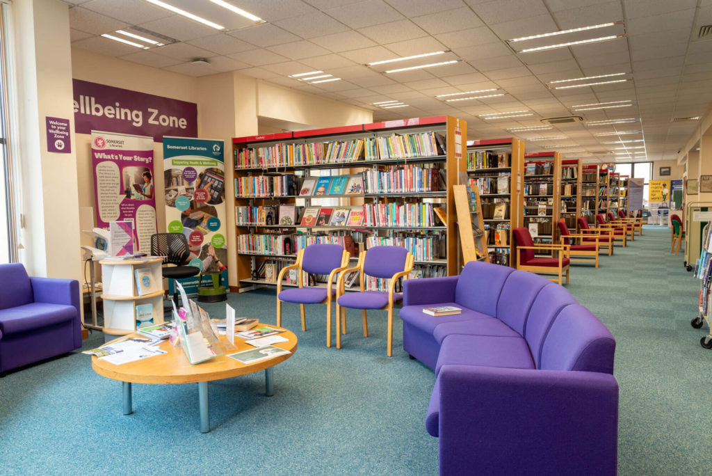 Health and wellbeing area at Yeovil Library with information displays, book collections, comfortable purple seating and dedicated space for reading, support and community health resources.