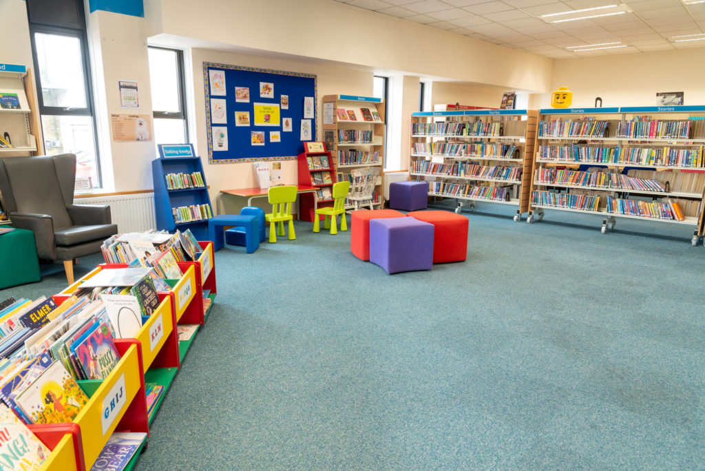 Children's area at Yeovil Library with picture book displays, colourful seating, activity tables, story book collections and open space for reading, learning and family activities.