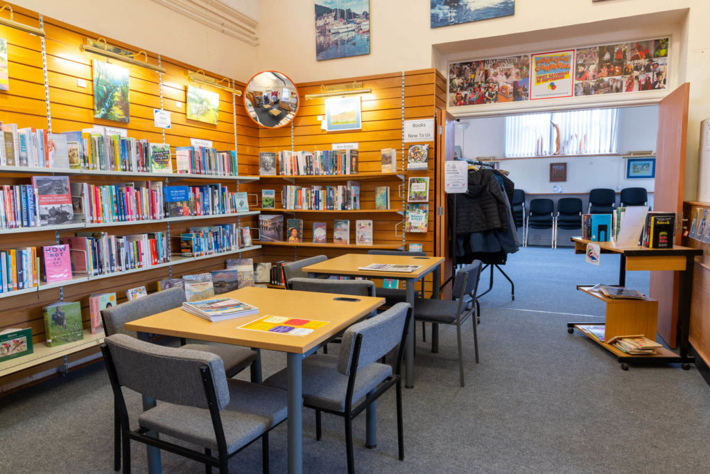 Reading and study area at Porlock Library with non-fiction book collections, study tables, seating and access to a community meeting room.