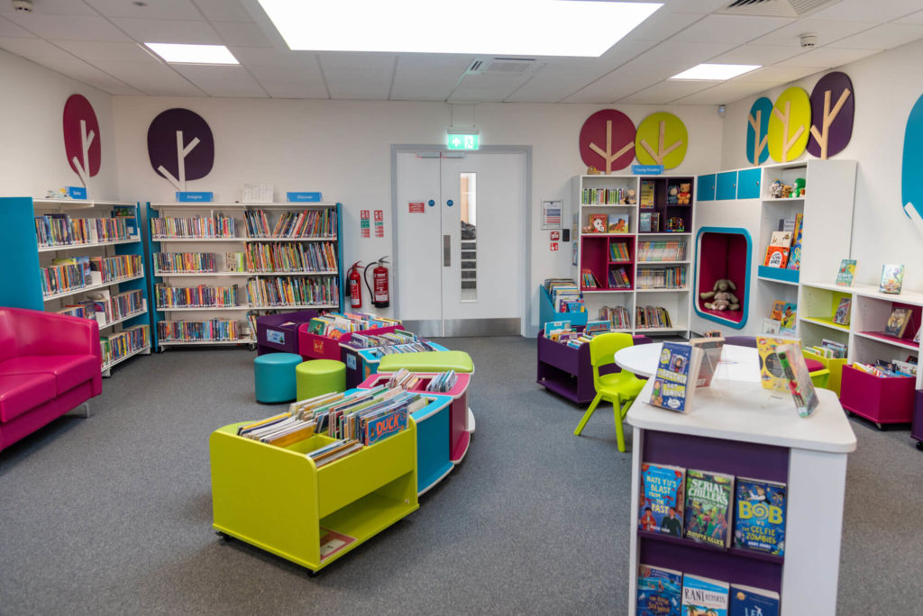 Children's area at Wellington Library with colourful book displays, low-level shelving, reading nook, activity table and seating for young readers and families.