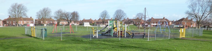 Picture of a playground with a climbing frame, slide and a set of swings