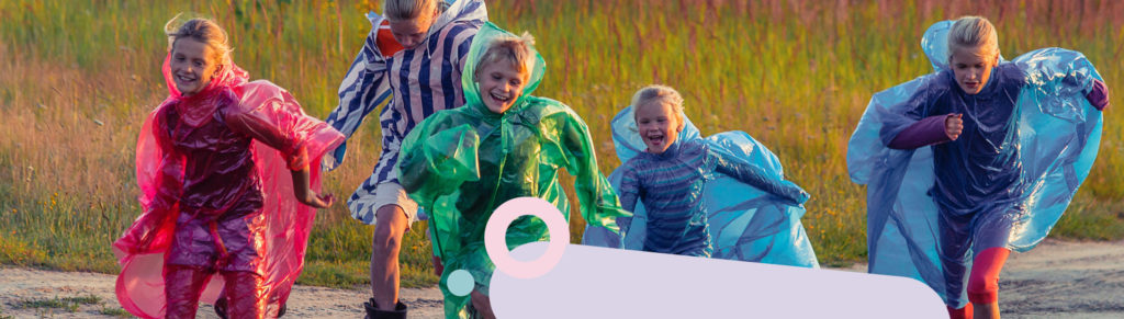Children in waterproofs running in a field
