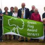 Photo of people holding a large banner which says Green Flag Award 2016 2017