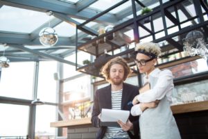 Two business people look at a clip board