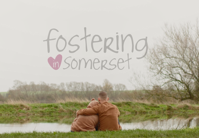 A man hugging a young person in a bear hoodie with the Fostering In Somerset logo