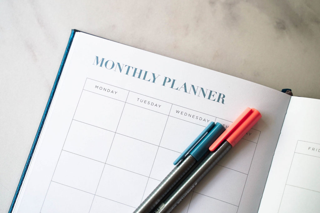 A monthly planner page and pens