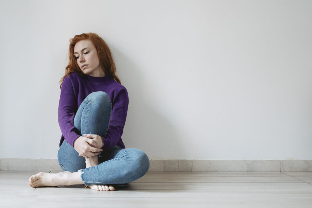 Vulnerable woman sitting on the floor