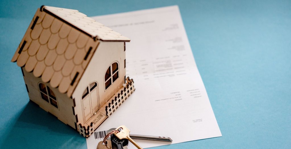 picture of a wooden house and set of keys on top of a paper document