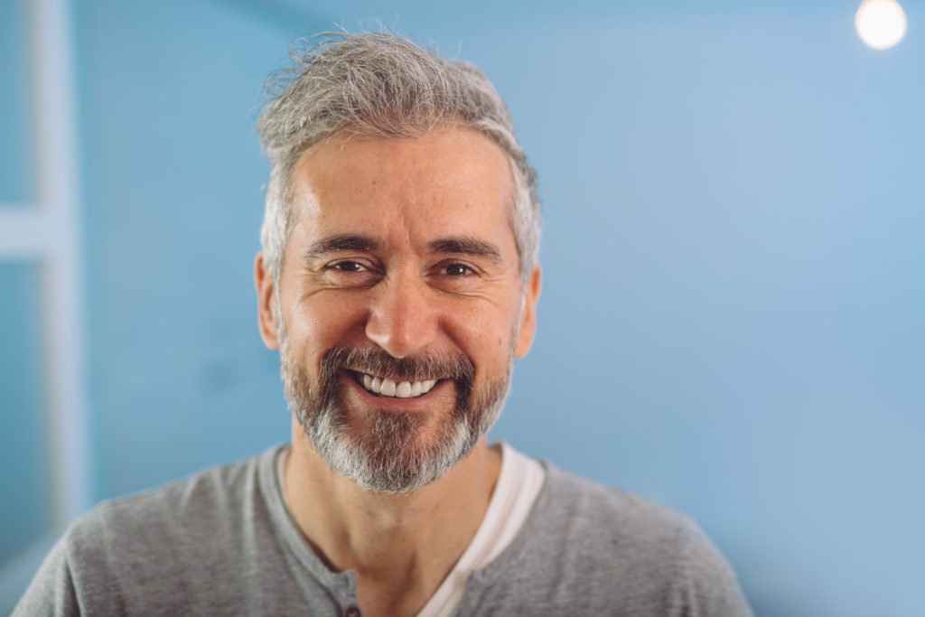 Happy middle aged grey haired bearded man