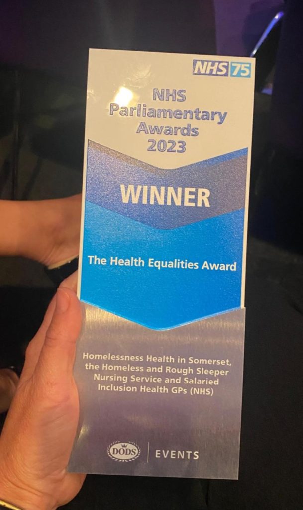 photo of a hand holding the NHS award