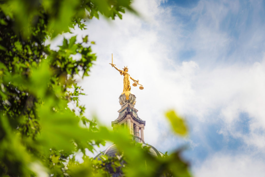 The gold coloured statue of Lady Justice, holding a sword and scales, on top of the dome of the Old Bailey, England's criminal court in the City of London.