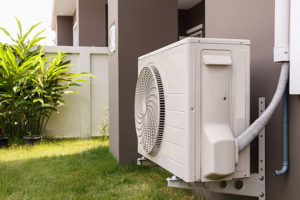 An air source heat pump mounted to the exterior of a house