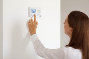 A woman setting the timer on a thermostat