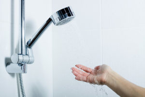 Someone testing the water temperature in a shower