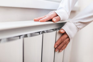 Someone placing their hand to test the temperature of a storage heating unit