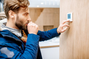 A man turning down the thermostat