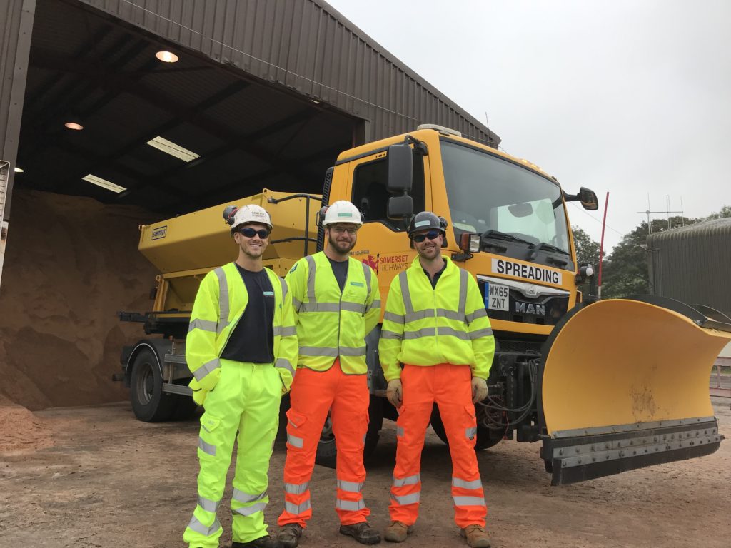 Image of gritting team and gritting vehicle behind