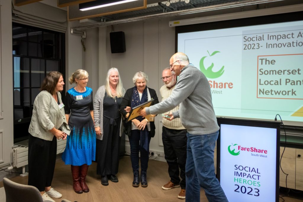 Photo of people stood in a line accepting a certificate at an awards event.