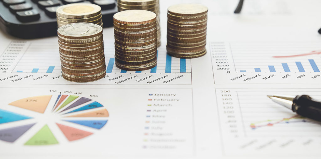 A calculator, pen and coins are placed on top of a budget planner.