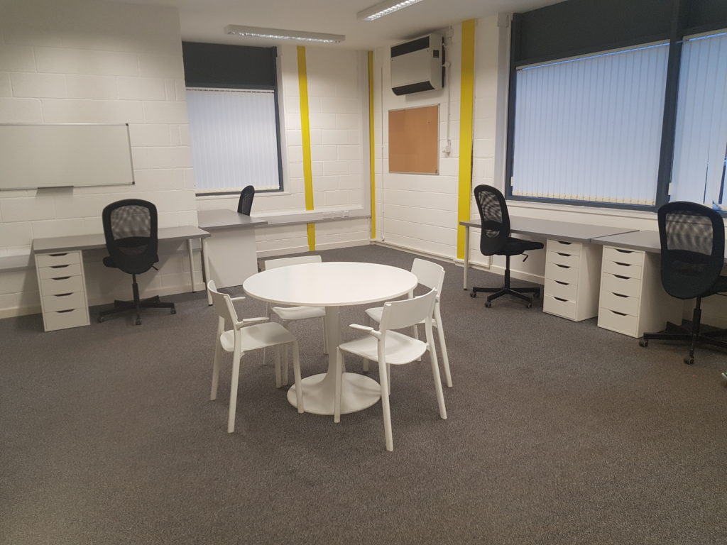 Minehead office space with desks and office chairs, and a white round table with four chairs