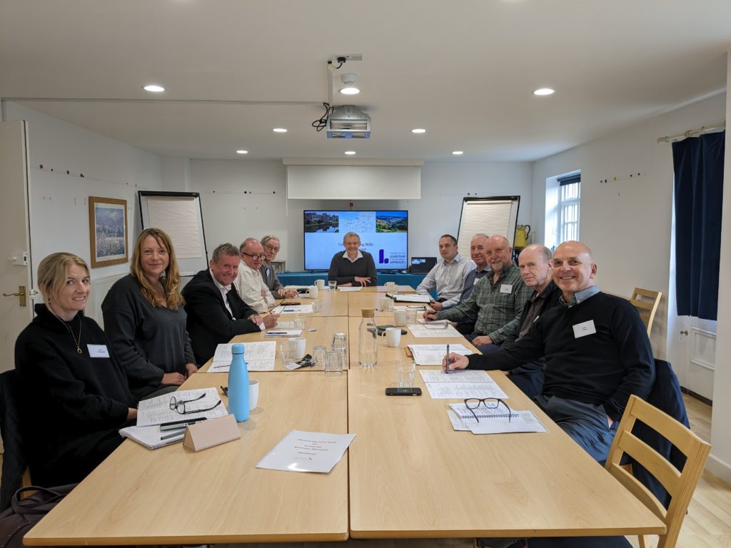 Photo shows the group of mentors sat around a table