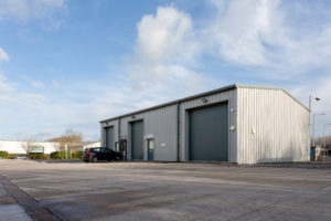 External view showing the 3 large roller doors on the side of the building. There is ample space for large vehicles to unload.
