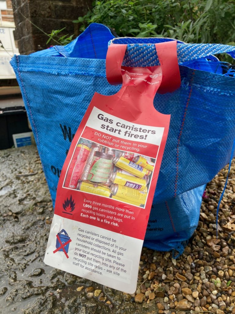 Red fire warning tag attached to the bright blue bag