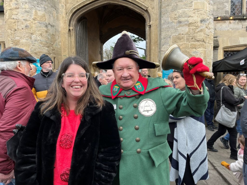 Cllr Federica Smith-Roberts and Wells Town Crier, Len Sweales standing in front of the Bishop's Eye, Wells.