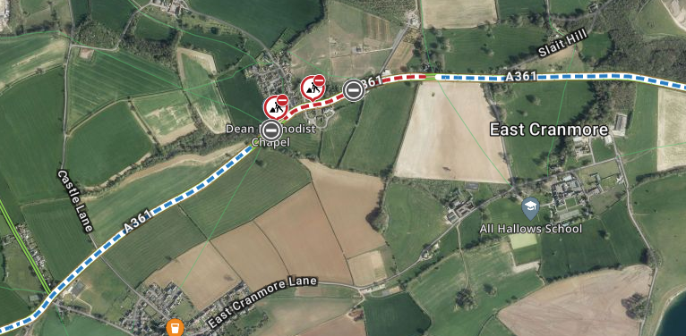 This image depicts a satellite map view of an area around East Cranmore, UK. The A361 road is prominently displayed, with a section of it marked in red and white indicating a closure. There are three red icons along the closed section of the road indicating no entry due to construction or maintenance work.