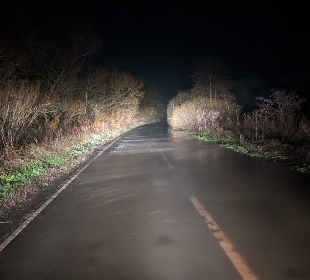 Flooded country road at night