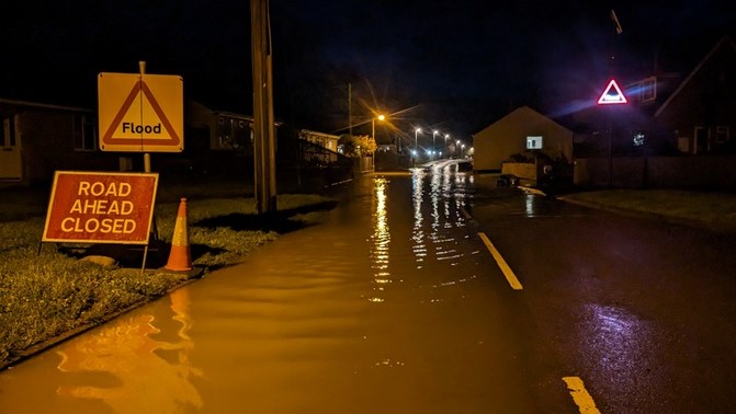 Early morning flooded road and warning signs