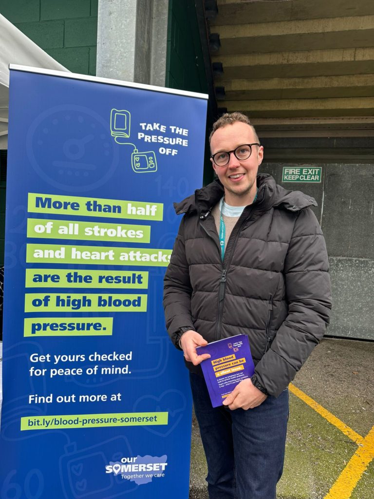 Cllr Adam Dance poses with a flier for blood testing