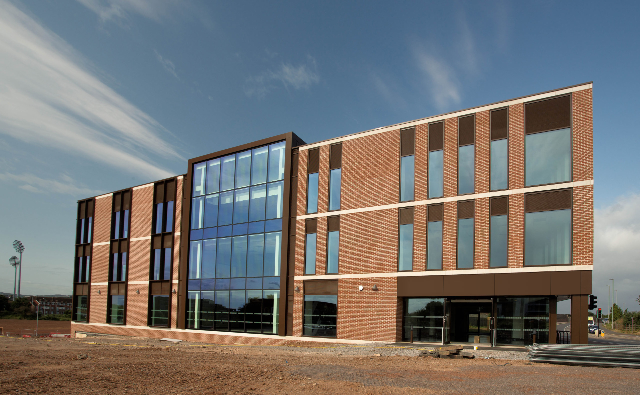 An outside view of the Firepool Centre for Digital Innovation. It is a three storey brick building with large floor to ceiling windows and a large section in the centre that is completely glazed