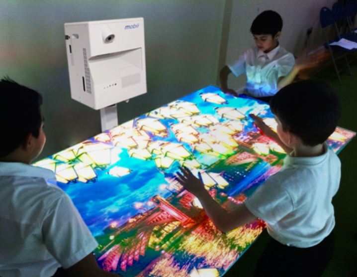 School children stood around a projector