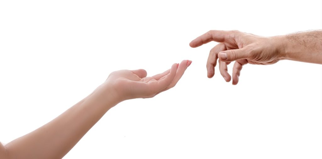 A photograph of two hands reaching out to each other