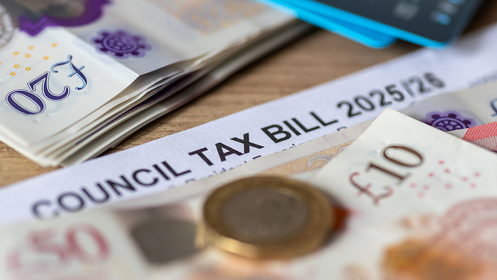 UK one pound coins placed on a 2025/26 Council Tax Bill.