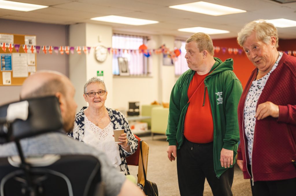 Four people chatting in a community setting.