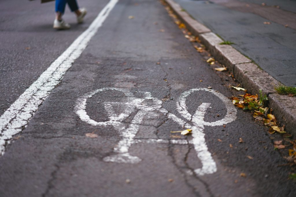 Stock image of a multi-use path, featuring a line-drawn cycling sign and a woman's legs walking in the background by Phil Hearing.
