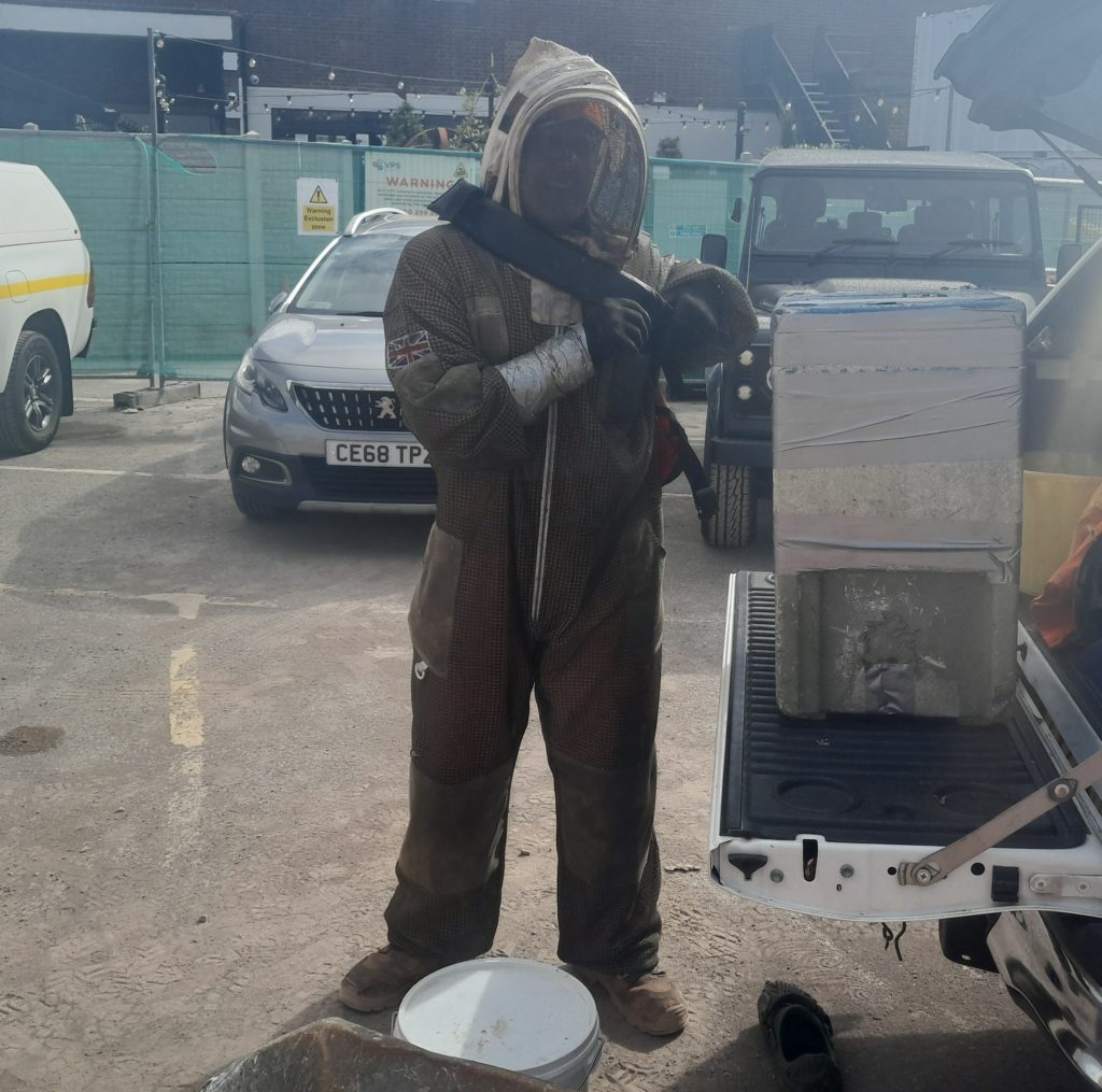 Perso n dressed in bee keeper suit